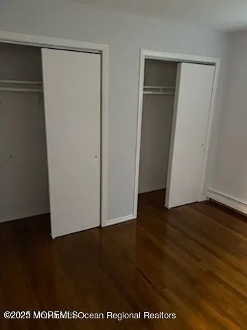 an empty room with wooden floor and closet