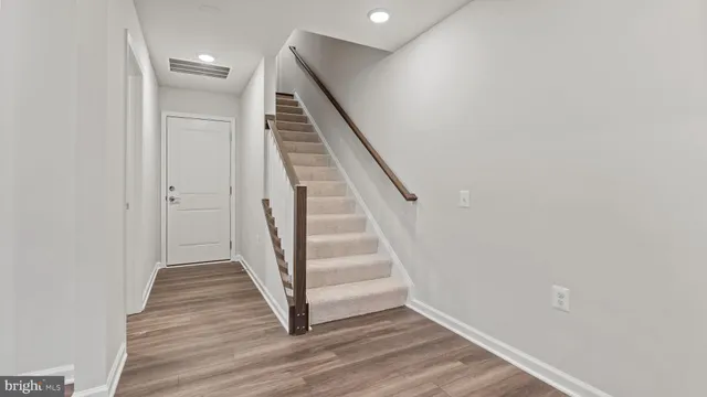 a view of a hallway with wooden floor and entryway