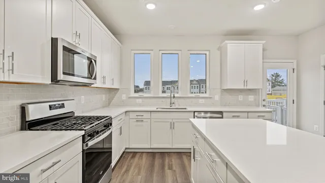 a kitchen with stainless steel appliances granite countertop a stove and a sink