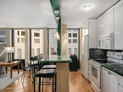 a kitchen with cabinets and chairs