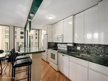 a kitchen with granite countertop a sink a stove and cabinets