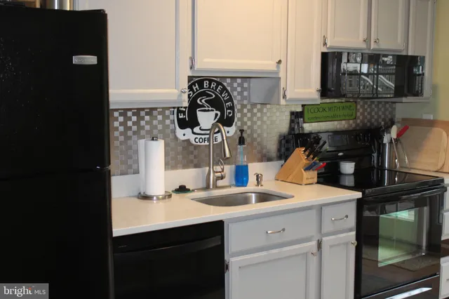 a kitchen with a sink appliances and cabinets