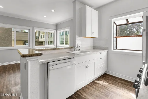 a kitchen with kitchen island a sink stainless steel appliances and a chandelier