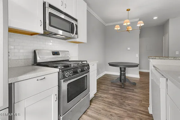 a kitchen with stainless steel appliances white cabinets and a stove top oven
