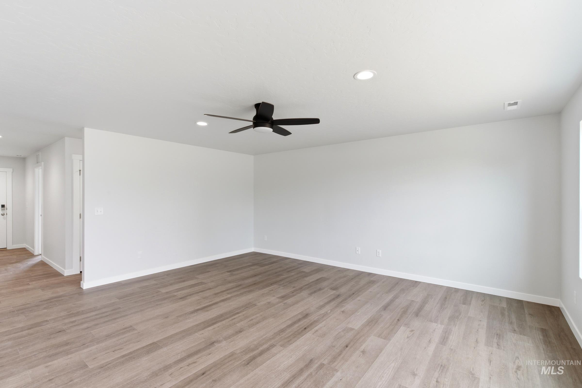 12829 Decatur Street Nampa, ID 83651 - Photo 8 of 33 Spacious room featuring wood-finish flooring, recessed lighting, a modern ceiling fan with integrated lighting, and white baseboards