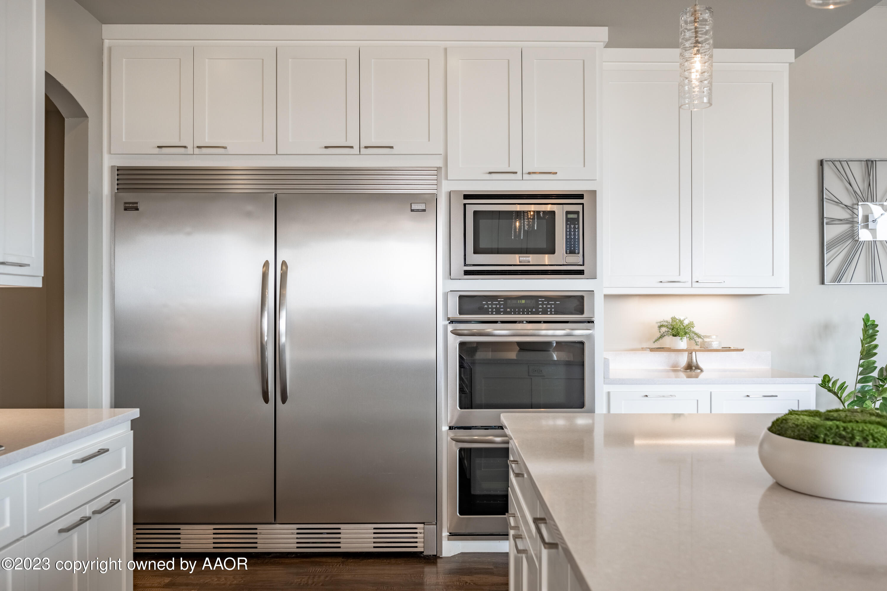 15300 Canyon Pass Road Amarillo, TX 79118 - Photo 17 of 51 a kitchen with stainless steel appliances kitchen island granite countertop a refrigerator a stove a sink and white cabinets with wooden floor