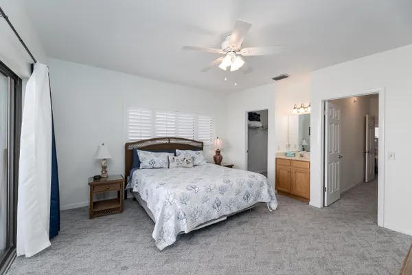 a bedroom with a large bed and a flat tv screen on dresser