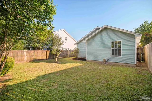 a view of backyard with wooden fence