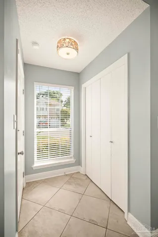 an empty room with wooden floor fireplace and windows