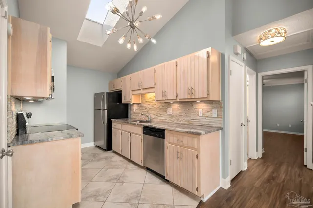 a kitchen with stainless steel appliances granite countertop white cabinets a stove top oven and microwave