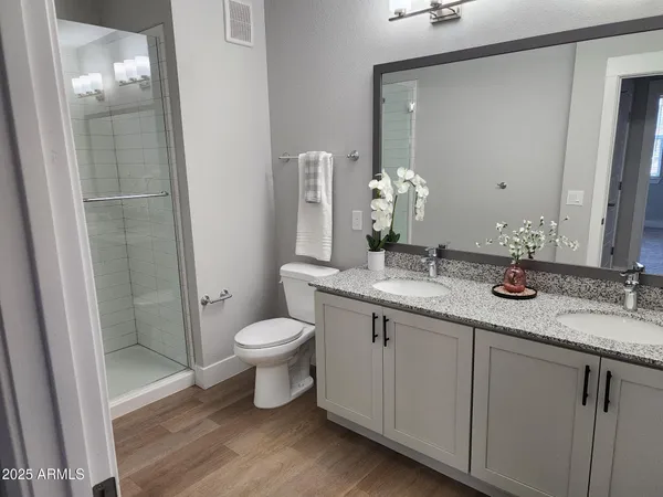 a bathroom with a granite countertop sink toilet and shower
