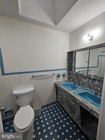 a bathroom with a granite countertop toilet sink and mirror
