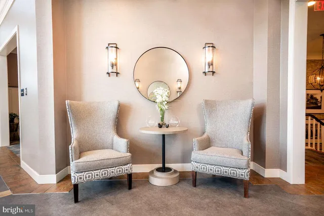 a living room with furniture a mirror and a lamp