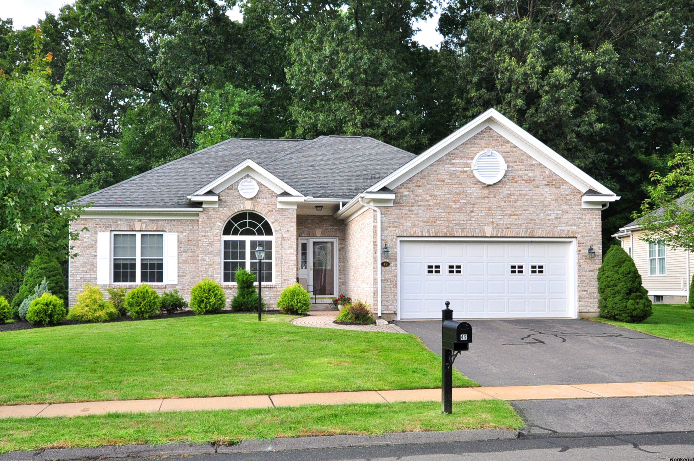 a front view of a house with a garden and plants