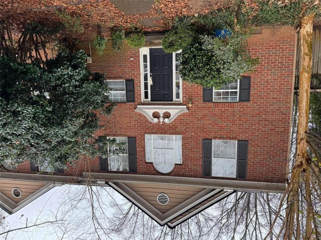 a front view of a house with yard and trees