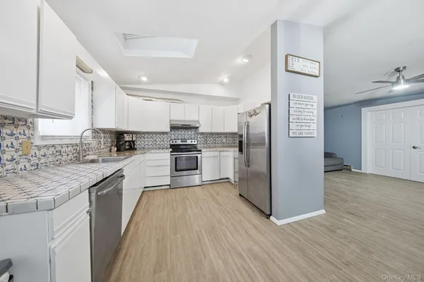 a kitchen with stainless steel appliances granite countertop a stove sink and refrigerator