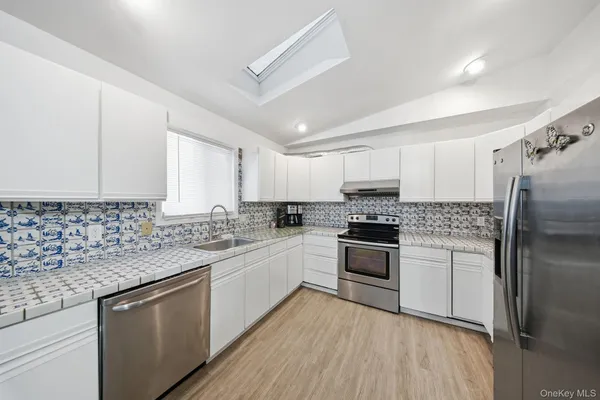 a kitchen with stainless steel appliances a refrigerator and wooden floor