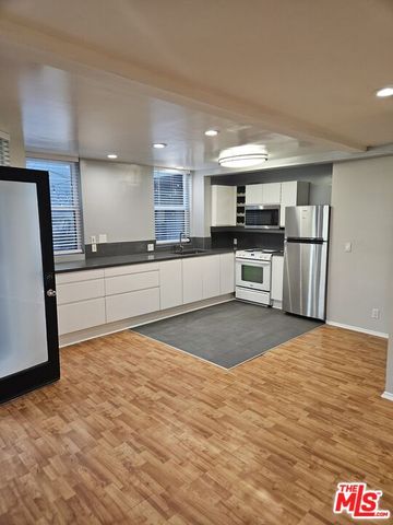 a kitchen with stainless steel appliances a refrigerator and a stove top oven