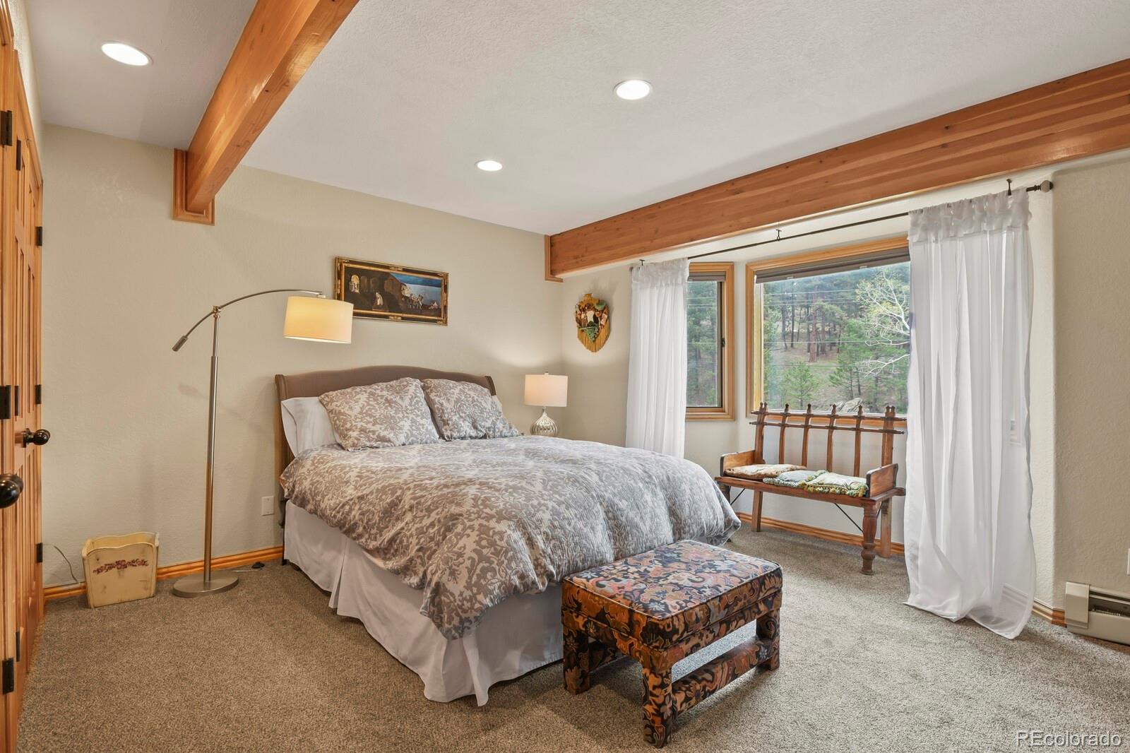 417 Witter Gulch Road Evergreen, CO 80439 - Photo 35 of 50 a bedroom with a bed and a night stand