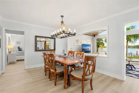 a view of a dining room with furniture a chandelier and wooden floor