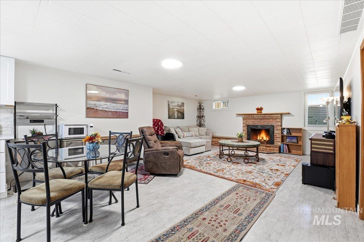 6710 West Ustick Road Boise, ID 83704 - Photo 18 of 42 Open-concept space featuring a brick fireplace with a wood mantle, recessed lighting, and light-tone flooring