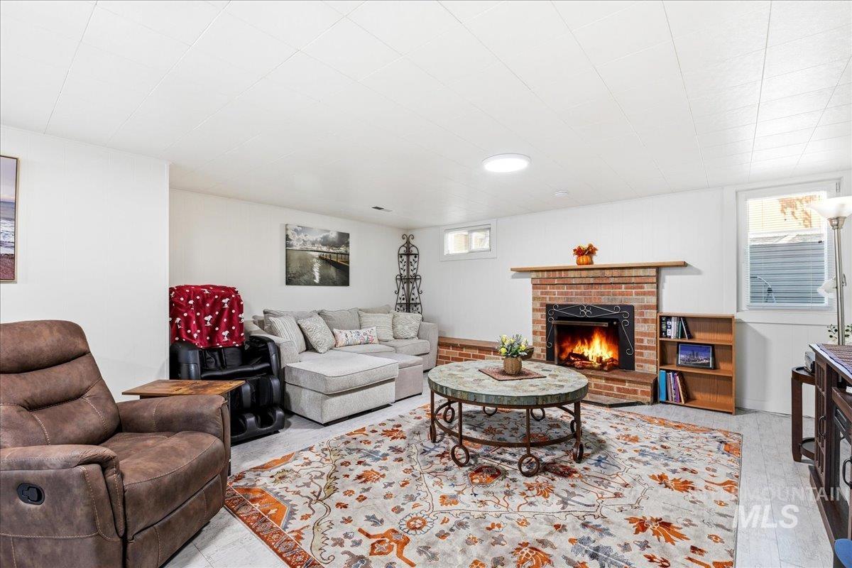 6710 West Ustick Road Boise, ID 83704 - Photo 19 of 42 Living area featuring a brick fireplace with a wood mantle and black firebox
