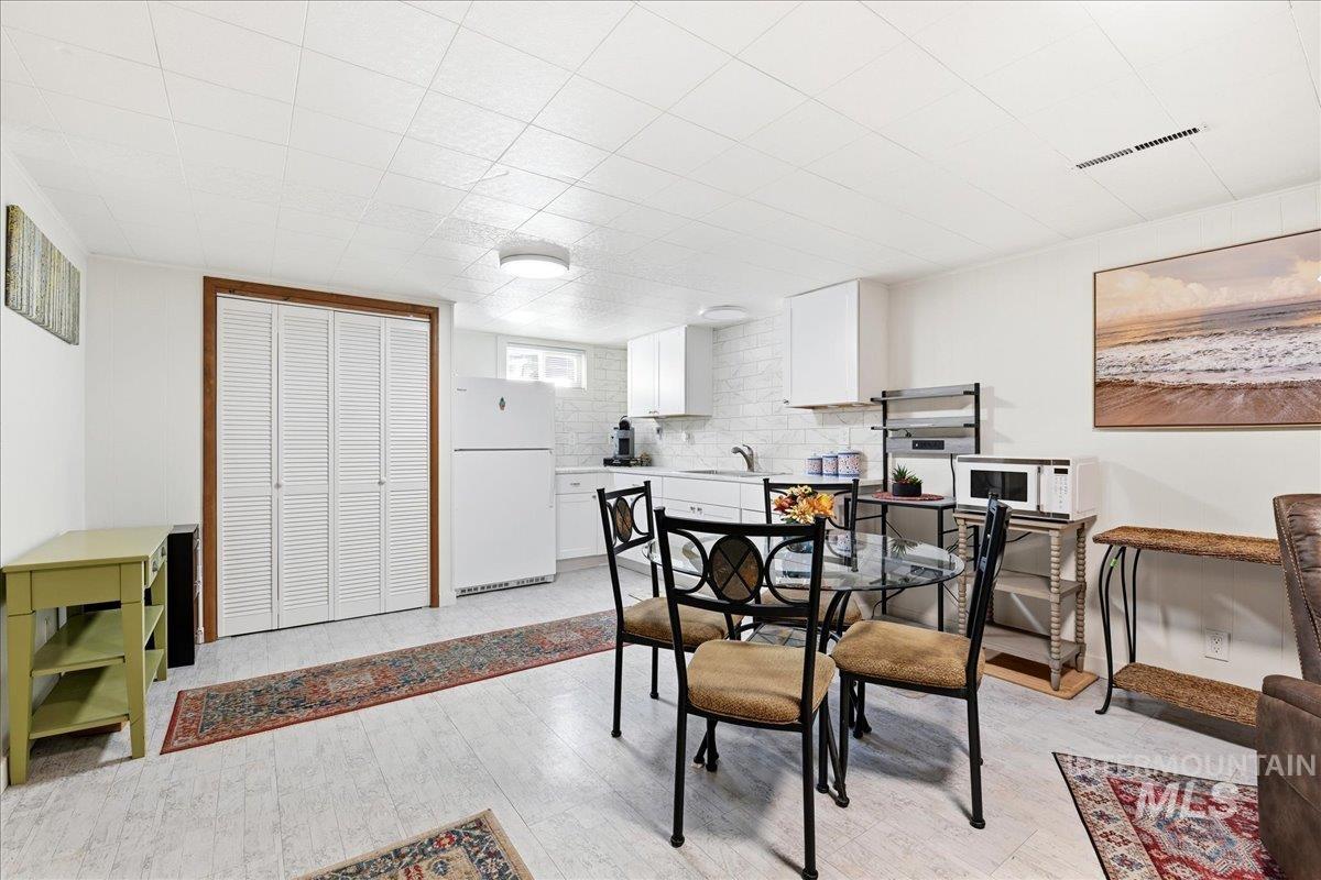 6710 West Ustick Road Boise, ID 83704 - Photo 21 of 42 Kitchenette featuring a white refrigerator, sink, and white subway tile backsplash