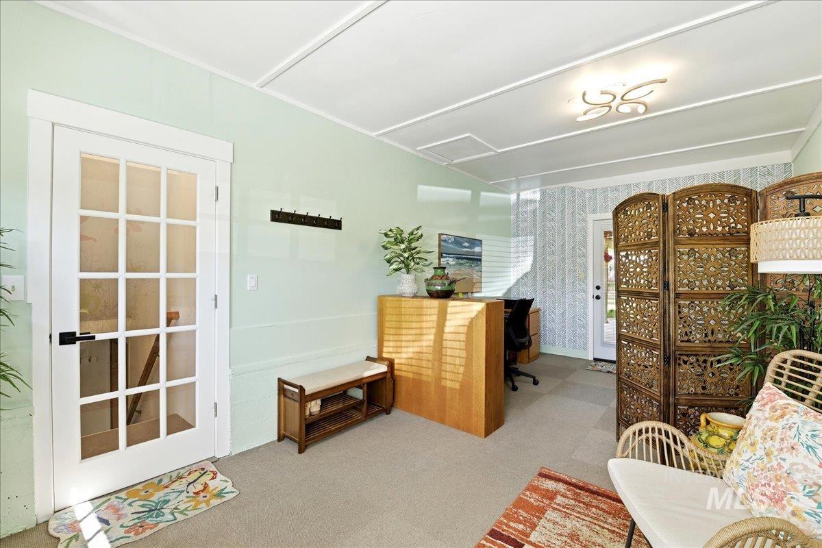 6710 West Ustick Road Boise, ID 83704 - Photo 27 of 42 Spacious room featuring light green walls, a French pane door with black hardware, and an ornate ceiling light fixture