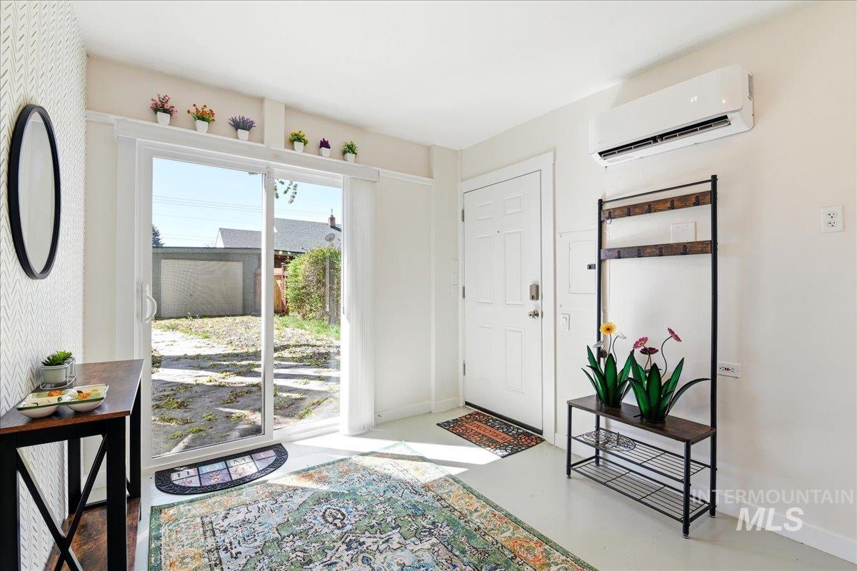 6710 West Ustick Road Boise, ID 83704 - Photo 30 of 42 ADU/ Air B and B -Entryway featuring a white paneled door, a sliding glass door, and a wall-mounted air conditioning unit