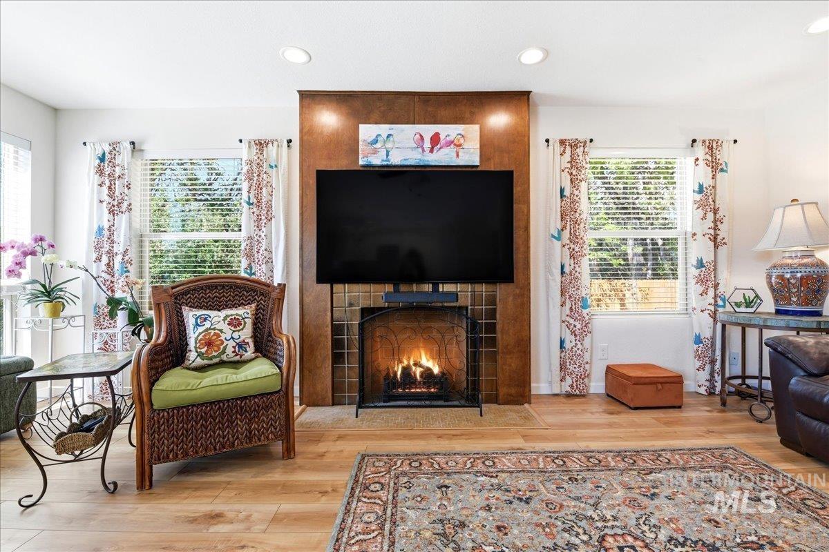 6710 West Ustick Road Boise, ID 83704 - Photo 7 of 42 Living area featuring a floor-to-ceiling fireplace with a tiled surround, recessed lighting, and wood-finish flooring