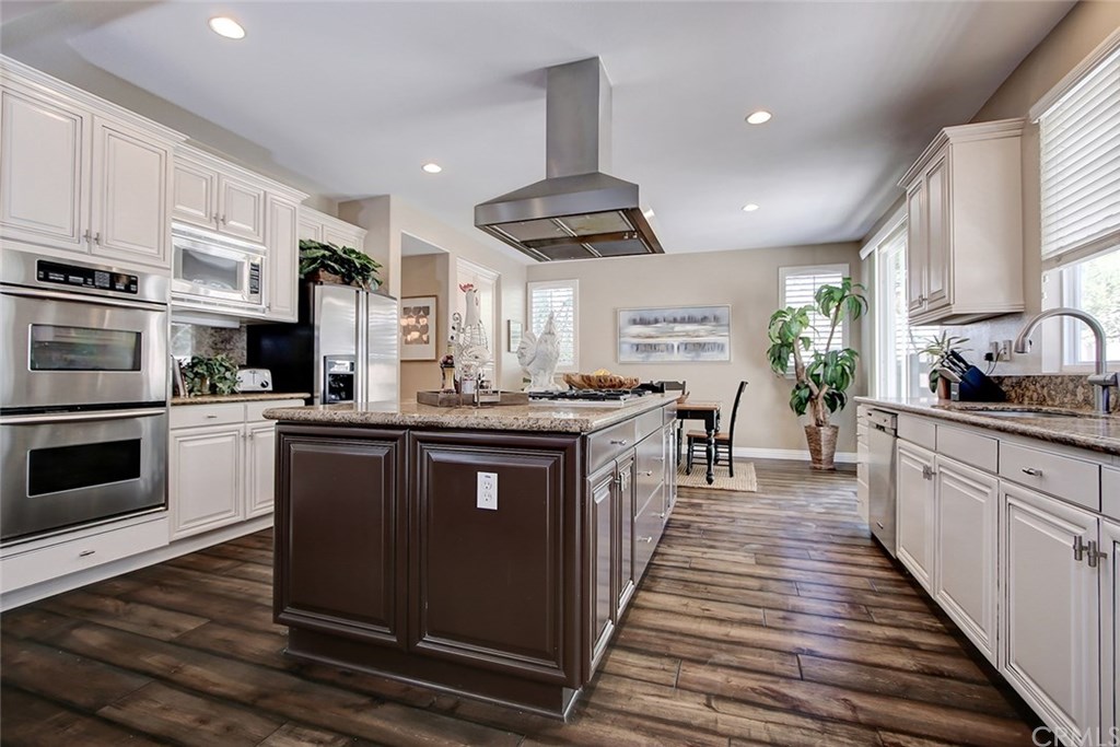 2911 Hawk Pointe Drive Fullerton, CA 92833 - Photo 22 of 55 Main Floor Gourmet Chef's Kitchen Features: Recessed Lighting, Granite Countertops, Kitchen Aid Stainless Steel Appliances, Grand Center Island with 5-Burner Gas Cooktop and Over-the-Range Stainless Steel Hood, Double Ovens, Built-In Microwave, Custom Painted Maple Cabinetry, and Hardwood Flooring.