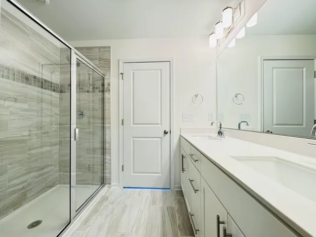 a spacious bathroom with a shower sink and mirror
