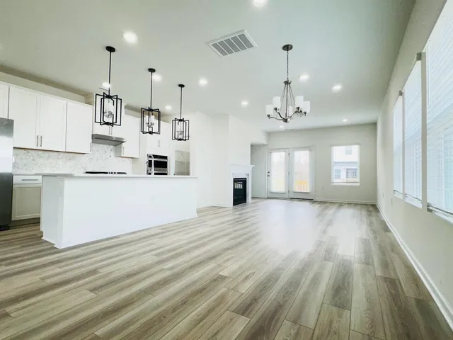 a view of a kitchen with wooden floor and windows