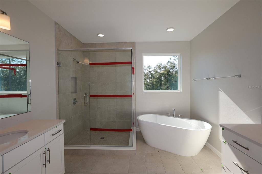 5184 Prairie Preserve Run St. Cloud, FL 34772 - Photo 13 of 36 a bathroom with a white bath tub a mirror and a toilet