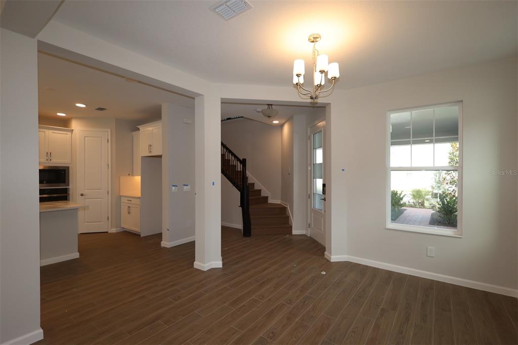 5184 Prairie Preserve Run St. Cloud, FL 34772 - Photo 27 of 36 a view of a hallway with wooden floor and a chandelier