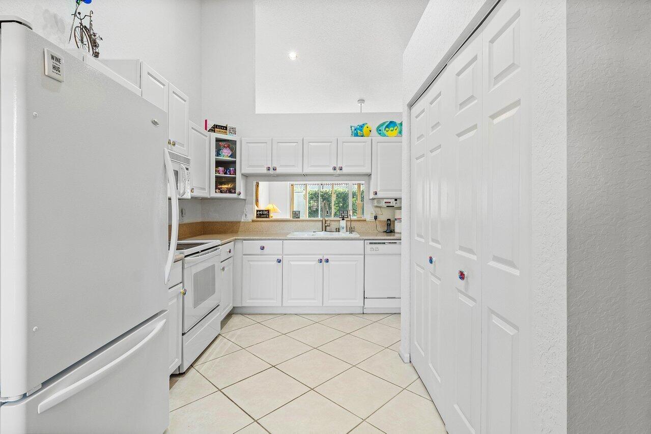 8398 Vía Serena Boca Raton, FL 33433 - Photo 4 of 50 a kitchen with white cabinets and white appliances