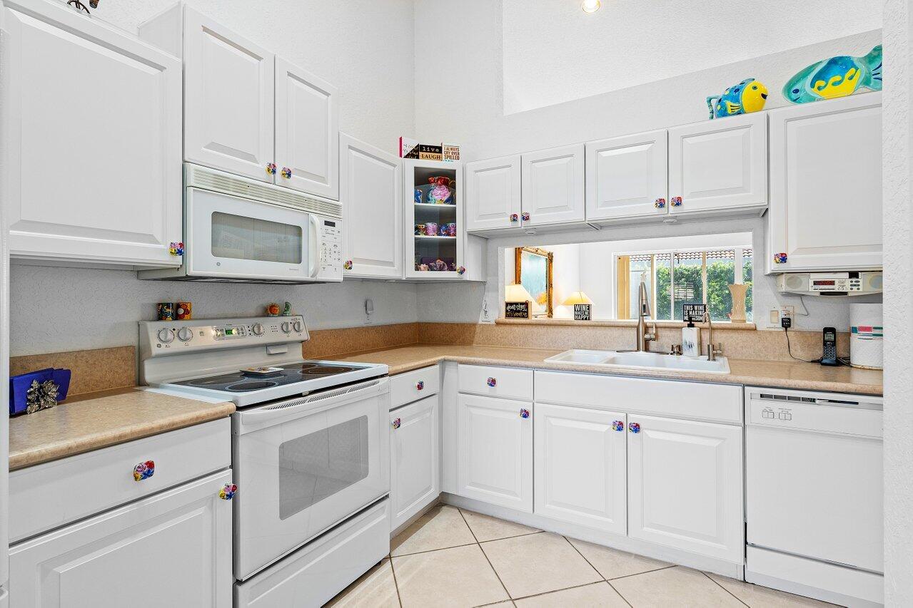 8398 Vía Serena Boca Raton, FL 33433 - Photo 5 of 50 a kitchen with cabinets appliances a sink and a window