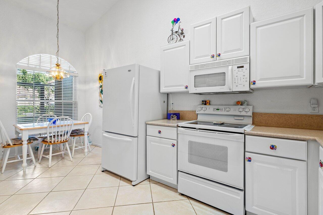 8398 Vía Serena Boca Raton, FL 33433 - Photo 6 of 50 a white kitchen with granite countertop white cabinets and white appliances