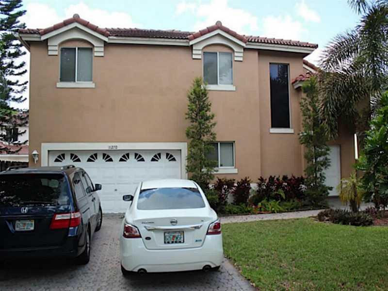 11270 Renaissance Road Cooper City, FL 33026 - Photo 2 of 17 a front view of a house with a garden
