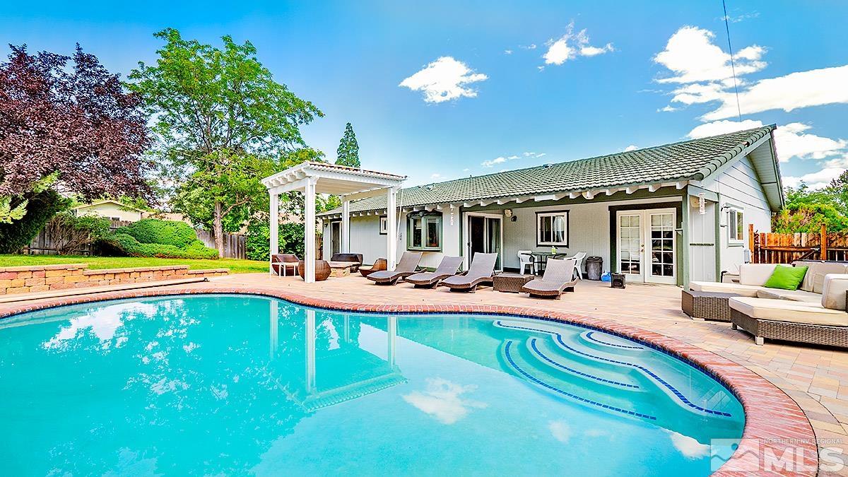 a view of a house with swimming pool and sitting area