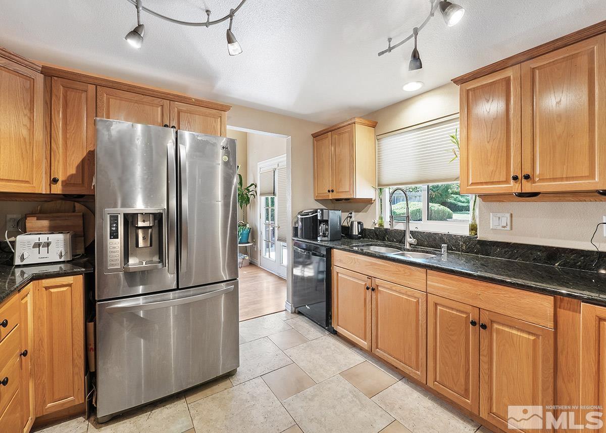 4155 Garlan Lane Reno, NV 89509 - Photo 3 of 24 a kitchen with granite countertop stainless steel appliances a refrigerator cabinets and a sink