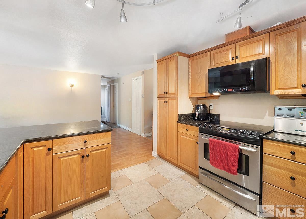 4155 Garlan Lane Reno, NV 89509 - Photo 4 of 24 a kitchen with granite countertop a stove a sink and a refrigerator