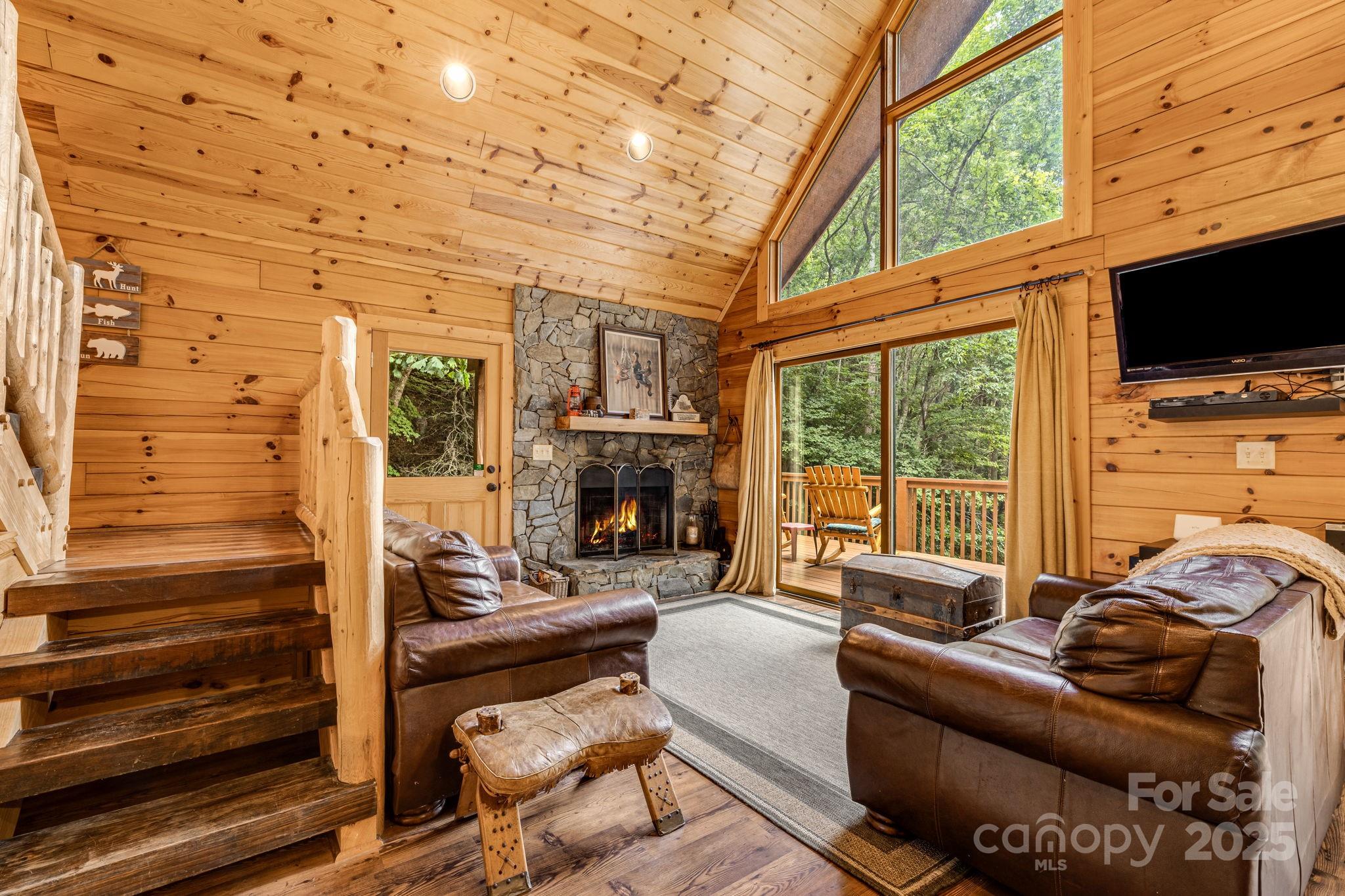 3617 Lonesome Mountain Road Marshall, NC 28753 - Photo 15 of 46 a living room with furniture a flat screen tv and a fireplace