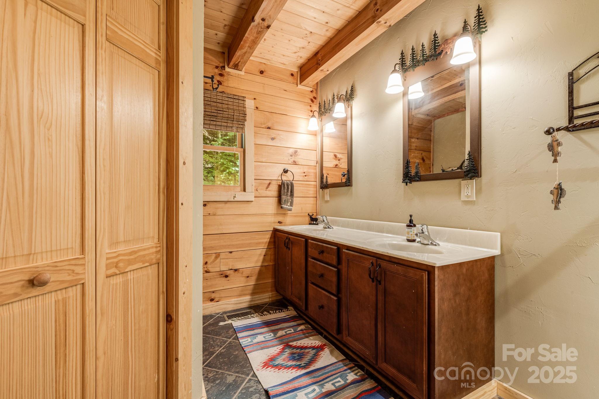3617 Lonesome Mountain Road Marshall, NC 28753 - Photo 27 of 46 a bathroom with a double vanity sink a mirror and a shower