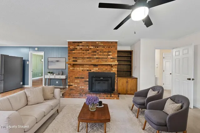 a living room with furniture ceiling fan and a fireplace