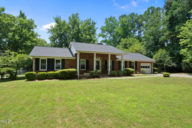 a front view of a house with yard and green space