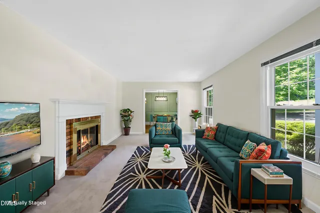 a living room with furniture a fireplace and a flat screen tv