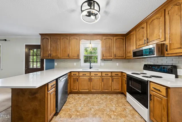 a kitchen with stainless steel appliances granite countertop a sink a stove and cabinets