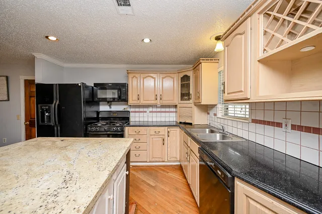 a kitchen with stainless steel appliances granite countertop a sink a stove and cabinets