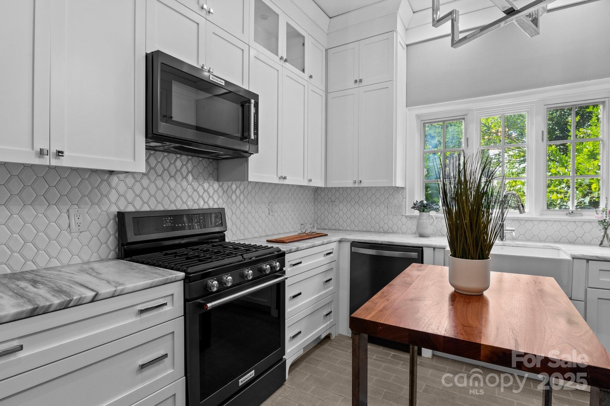 560 Concord Road Davidson, NC 28036 - Photo 18 of 34 a kitchen with stainless steel appliances a stove microwave and cabinets
